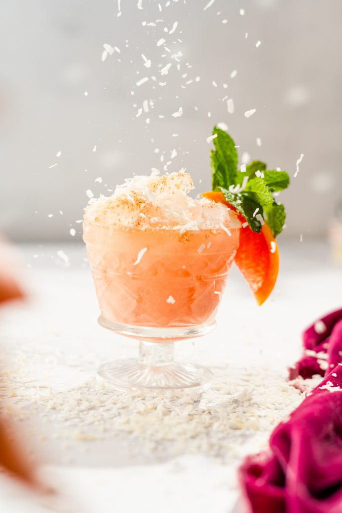 picture of cocktail recipe of a pink coconut drink with mahina coco liqueur, campari, cold brew coffee sherry and coconut cream