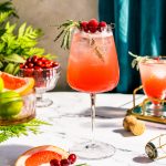 bubbly red cocktail with rosemary and cranberries