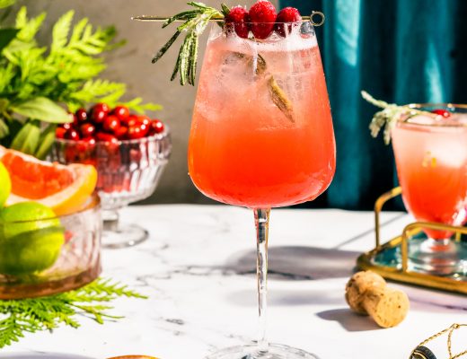 bubbly red cocktail with rosemary and cranberries