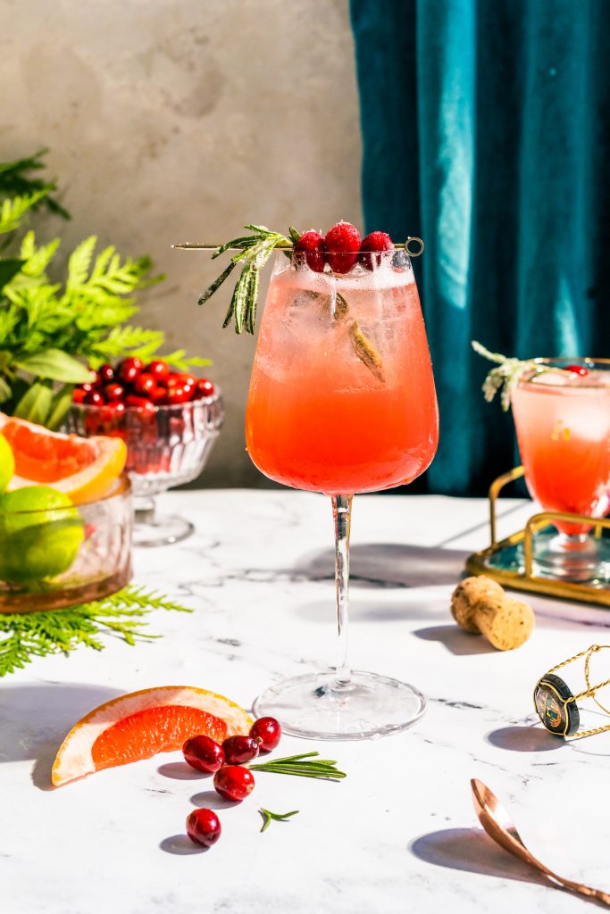 bubbly red cocktail with rosemary and cranberries